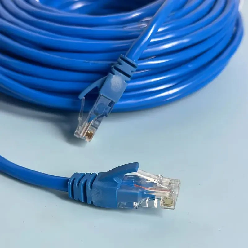 A blue Cat6 Ethernet patch cable is coiled and a loose connector end is shown on a light surface.