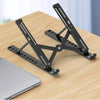 Black adjustable foldable laptop cooling stand resting on a wooden surface.