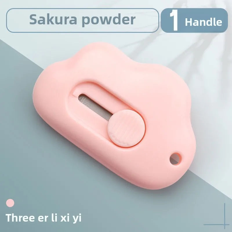 Rosa Sakura-Pulverwerkzeug mit Griff und runder Knopf vor hellblau-grauem Hintergrund