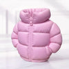 A pink puffer jacket shaped like a pen holder or desk organizer resting on a white surface.