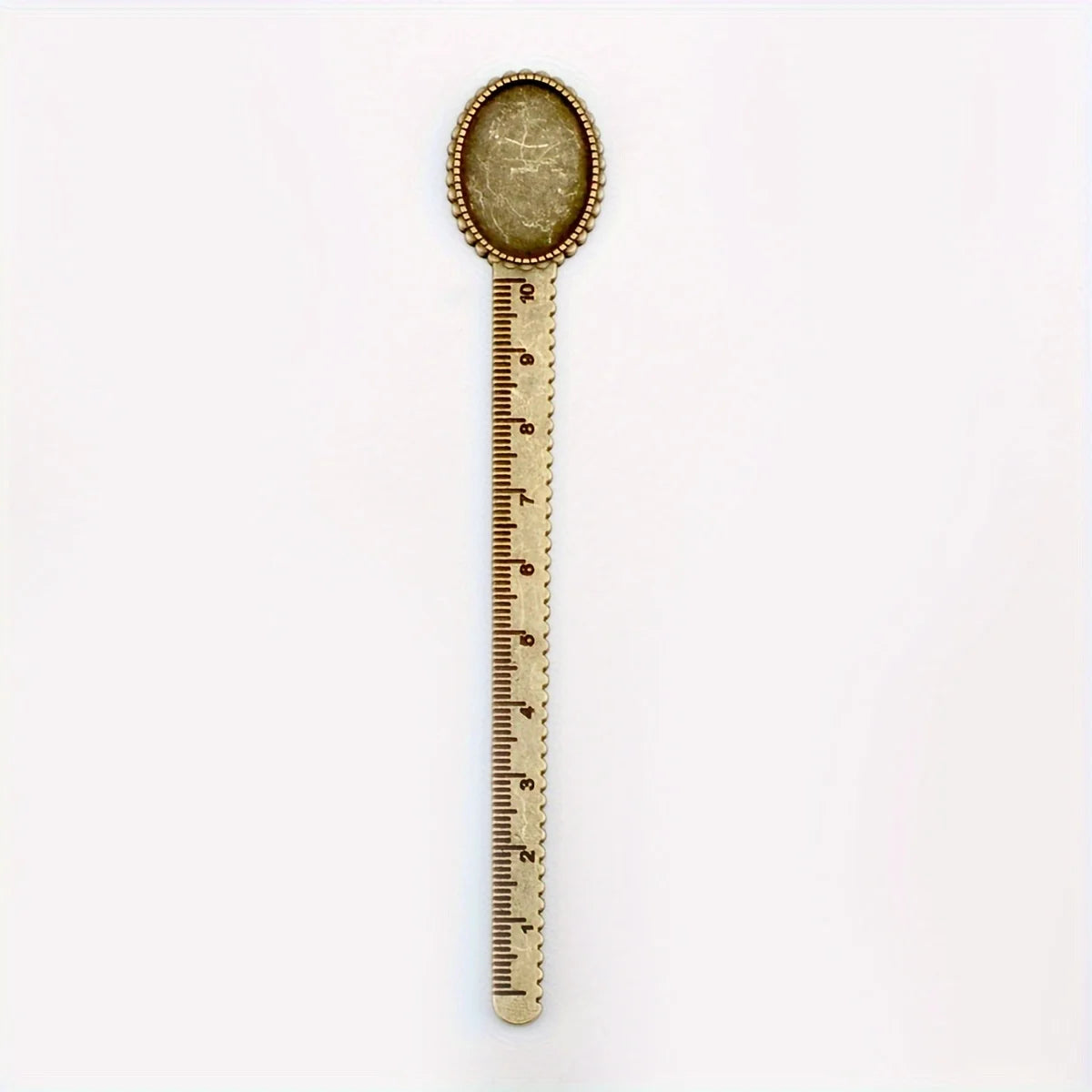 Vintage brass straight ruler with a round, textured tip and minimalist design.