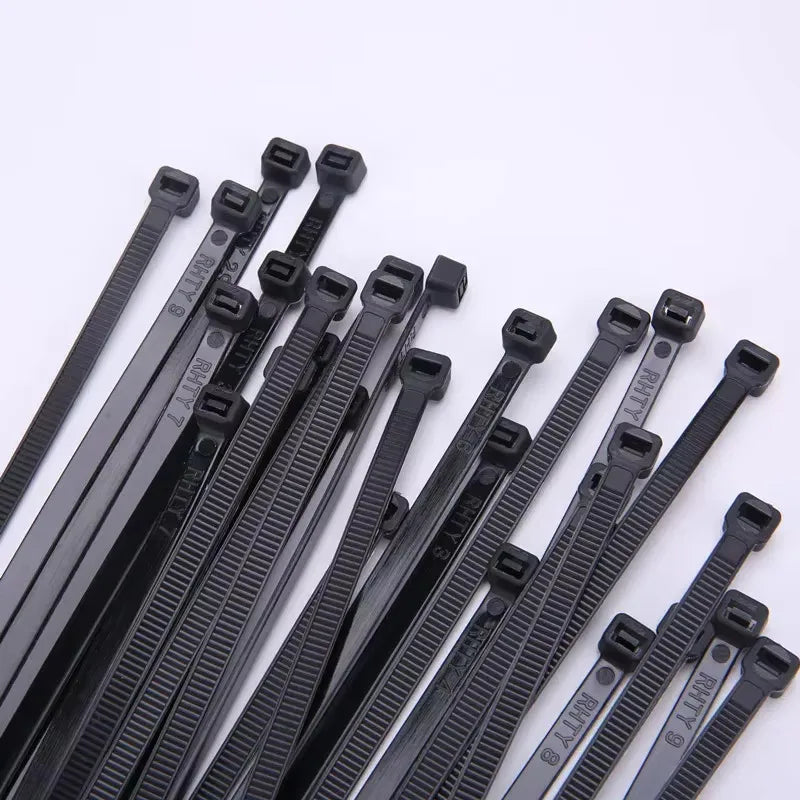 A collection of black heavy-duty nylon cable ties with self-locking designs arranged diagonally.