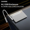 Silberne M.2 NVMe SSD-Gehäuse mit weißem Kabel auf dunkler Laptop-Oberfläche.
