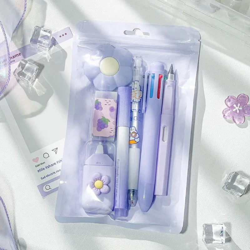 A clear plastic pouch containing a set of cute cartoon school stationery including a purple eraser and pens.