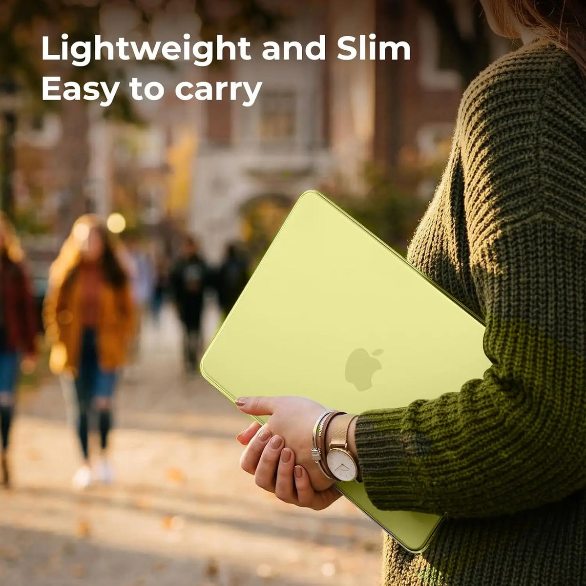 A person holds a light green durable hard shell cover for a MacBook Pro in an outdoor setting.