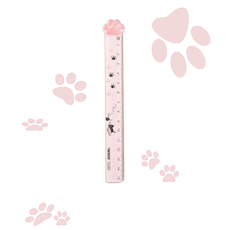 A pink plastic ruler shaped like a cat paw, featuring paw prints and a heart design.
