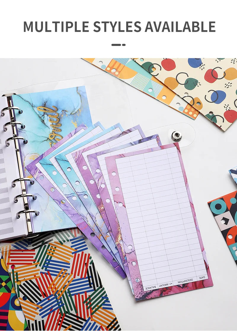 A stack of colorful A6 budget planner binders and sheets with decorative covers are displayed on a white surface.
