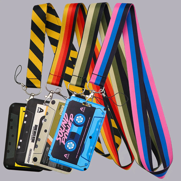 A collection of vintage cassette tape lanyards and an ID badge holder displayed against a gray background.