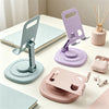 A set of purple and mint green 360° rotating foldable desktop phone stands displayed on a white surface.