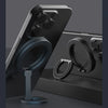 A black MagSafe double-sided phone ring holder is shown on a dark surface.