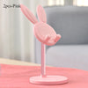Two pink rabbit-shaped mobile phone stands with a pink base shown on a pink surface.
