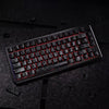 A close-up view of a black mechanical keyboard with red backlit carbon fiber keycaps resting on a dark surface.