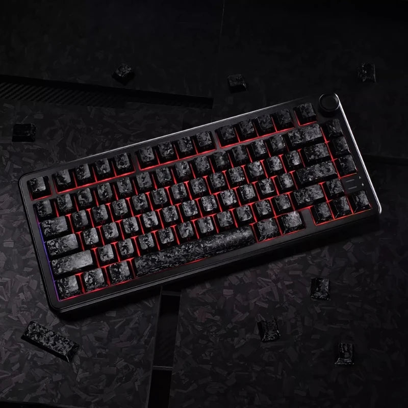 A close-up view of a black mechanical keyboard with red backlit carbon fiber keycaps resting on a dark surface.