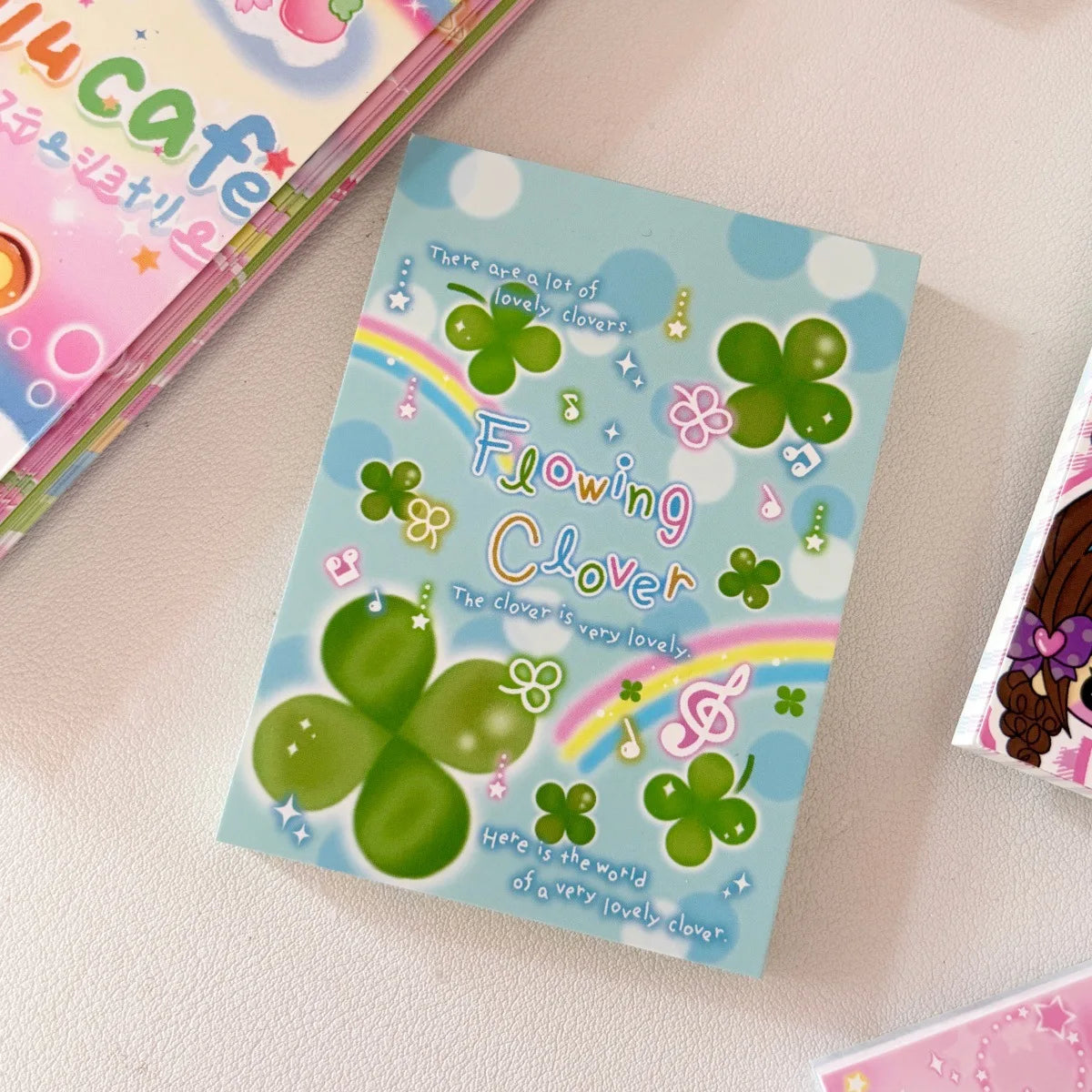 A square memo pad featuring a green four-leaf clover design and text about the lovely clover.