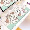 A cartoon cat design desk mat featuring white and pink cats on a light green background.