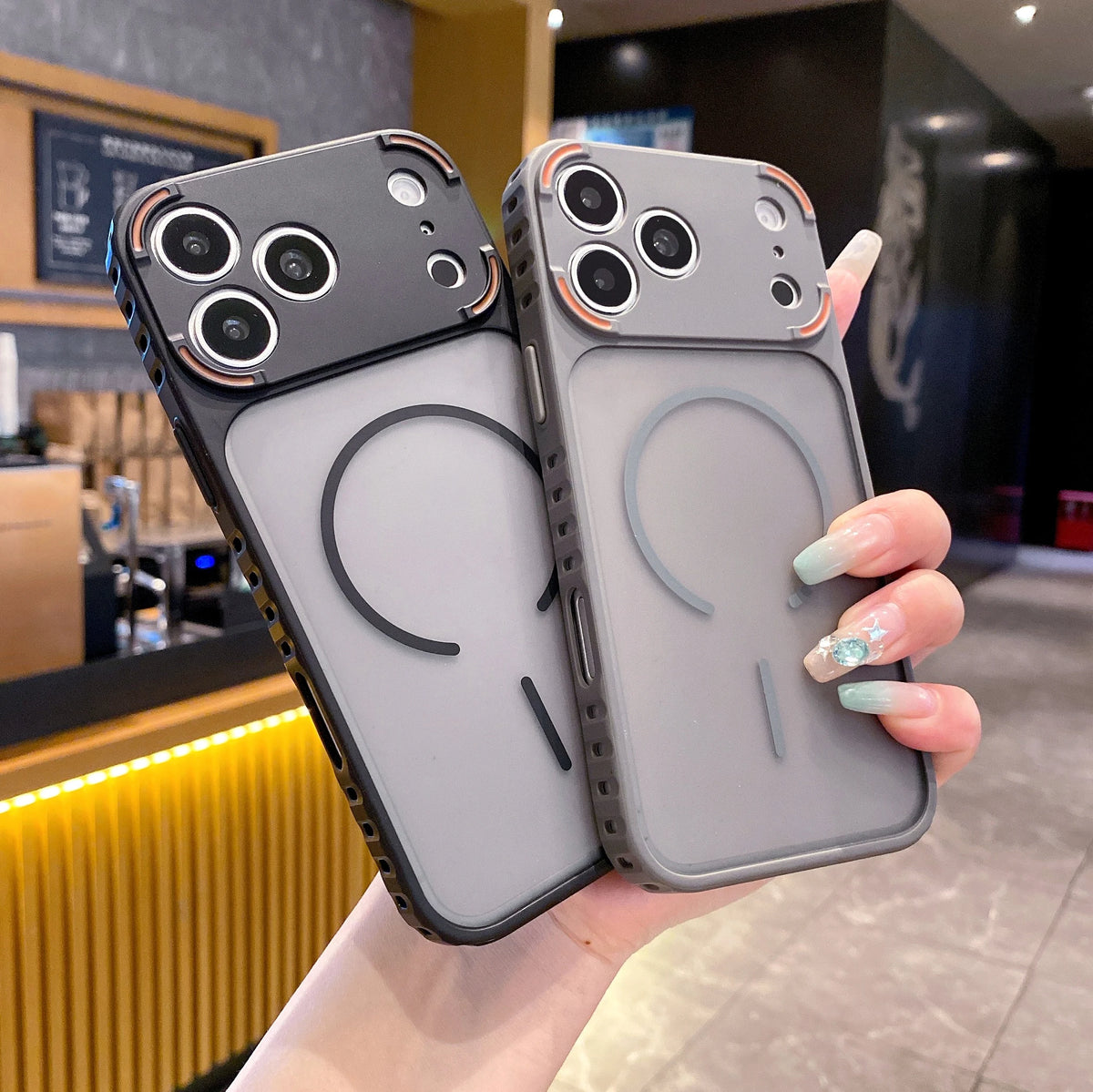 A hand holds a gray frosted magnetic silicone case for an iPhone, displaying the back design.