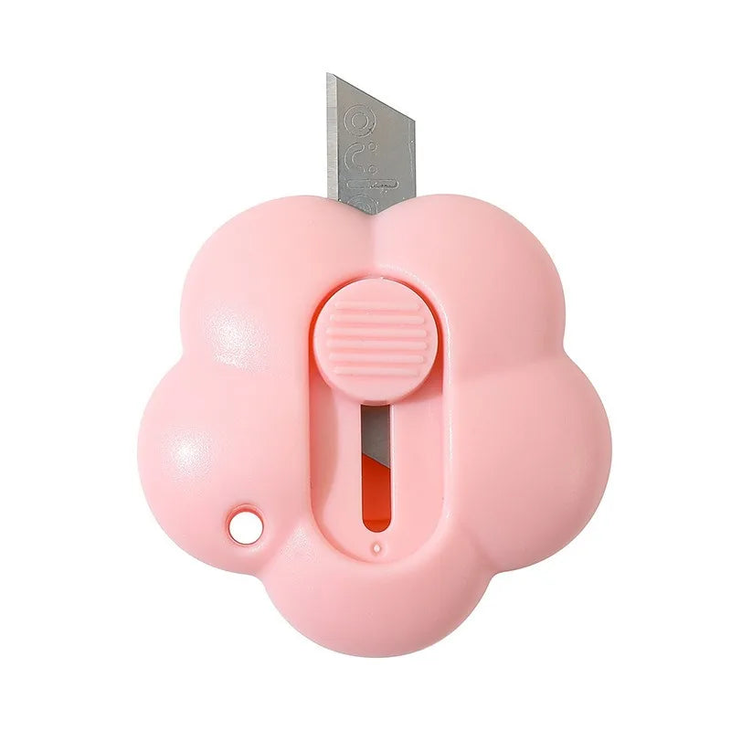 A pink floral-shaped letter opener and paper cutter with a metal blade.