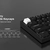 A close-up view of black mechanical keyboard keycaps with a cherry profile, showing various key sizes and a white escape keyc