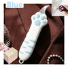 A white and blue cat paw shaped utility knife is shown against a brown fabric background.