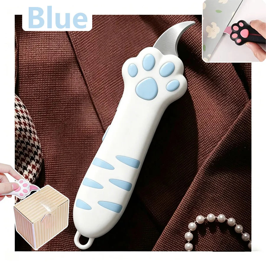 A white and blue cat paw shaped utility knife is shown against a brown fabric background.