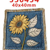 A fabric embroidery featuring a large yellow sunflower and several green leaves on a dark blue background.