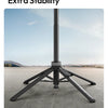 A black four-leg tripod stand is shown on a gray surface, demonstrating its stability features.
