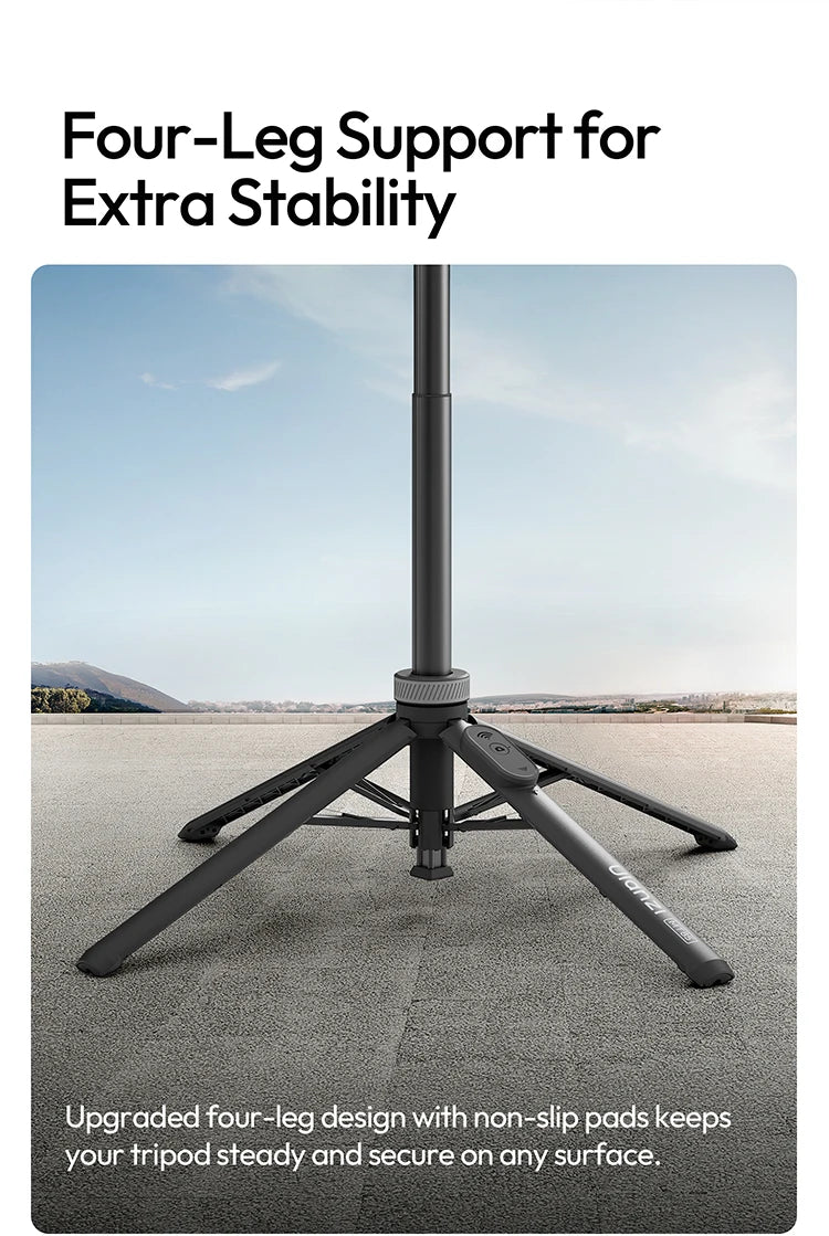 A black four-leg tripod stand is shown on a gray surface, demonstrating its stability features.