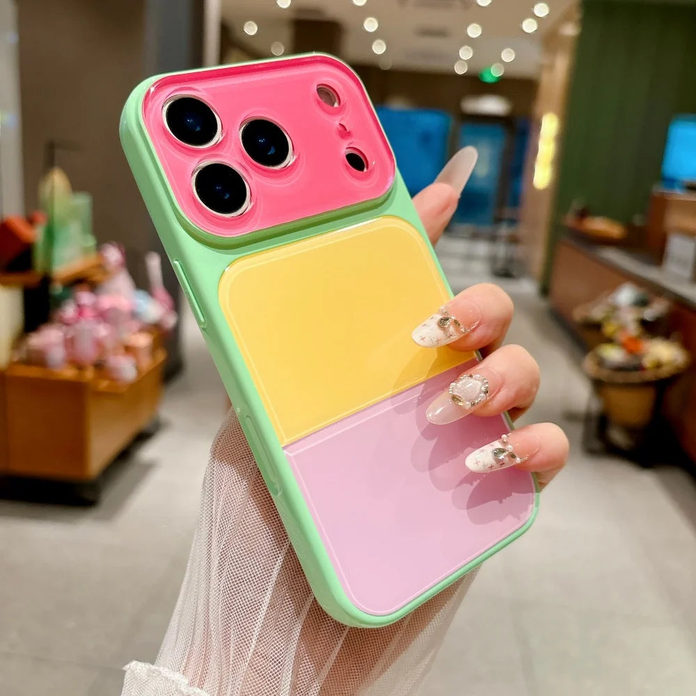 A hand holds a colorful block acrylic phone case with pink, yellow, and green sections.
