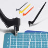 A set of yellow, orange, and black steel art cutting tools with a black handle shown above a grid ruler.