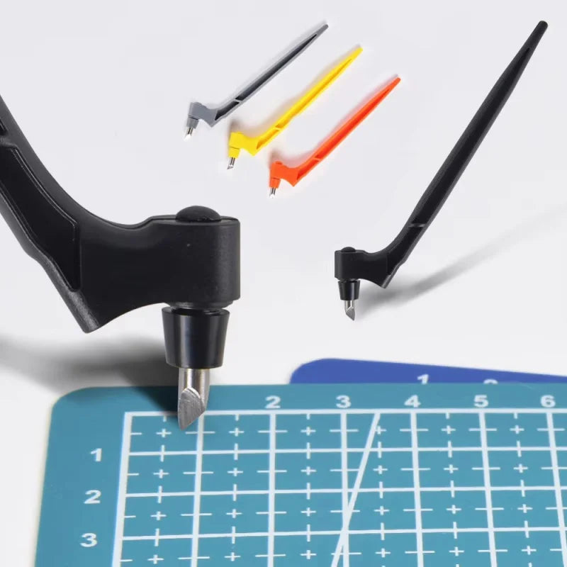 A set of yellow, orange, and black steel art cutting tools with a black handle shown above a grid ruler.