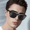 A man wearing black intelligent solar sunglasses outdoors.