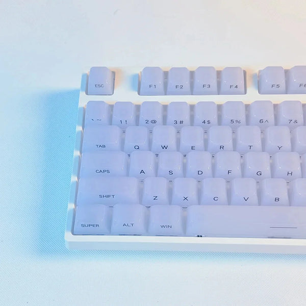 A close-up view of white custom profile keycaps for a mechanical keyboard, showing various function and alphanumeric keys.