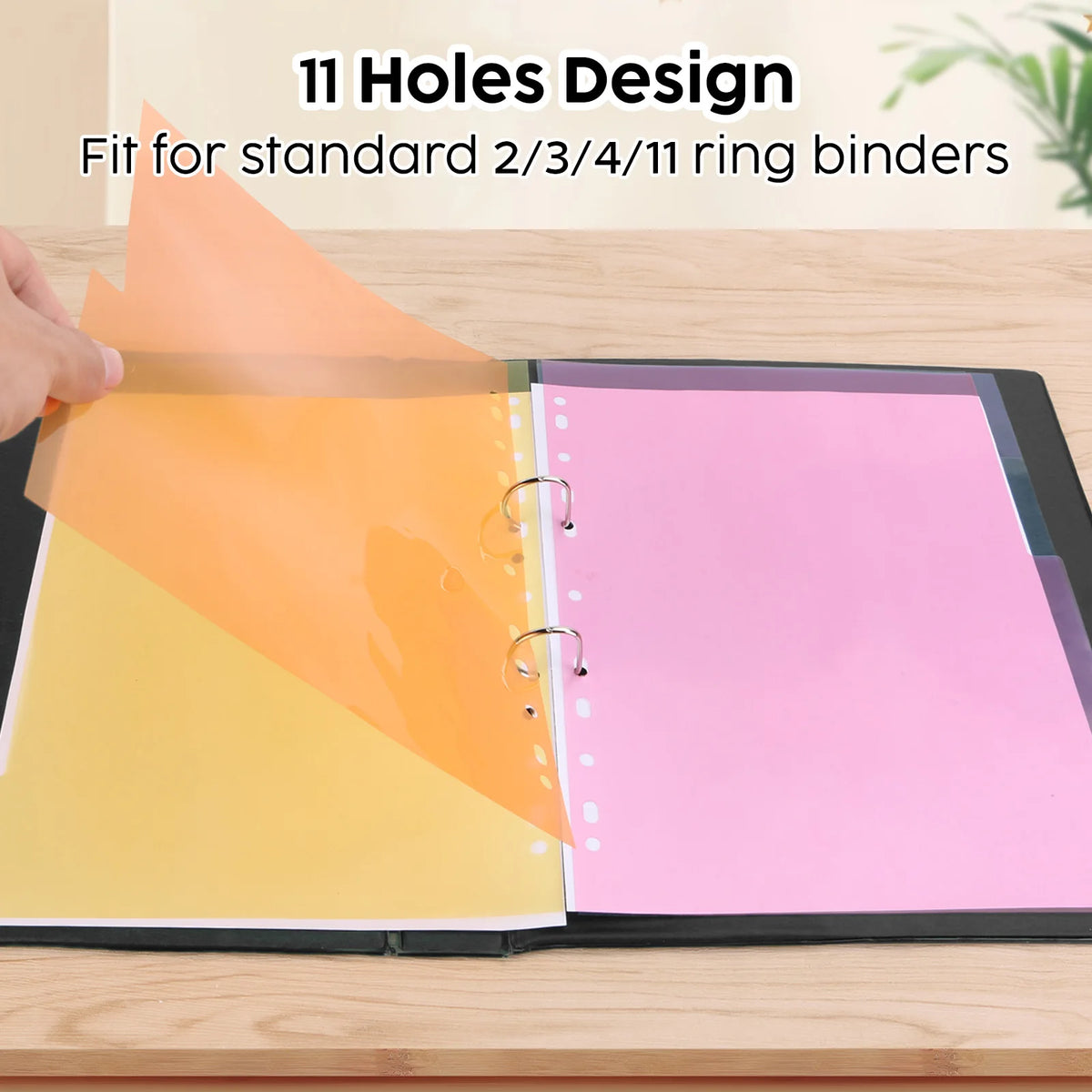 A close-up of an orange and yellow A4 index divider with 11 holes, shown next to a pink notebook.