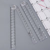 A set of clear acrylic geometry rulers and a grid, showing various measurement scales.