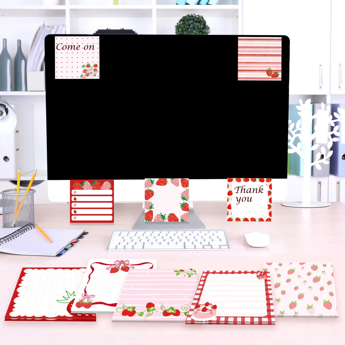 A set of strawberry shaped self-stick memo notes in various colors and patterns displayed on a desk.
