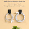 A black and white cable organizer kit with a reusable loop and attachment for managing desk wires.