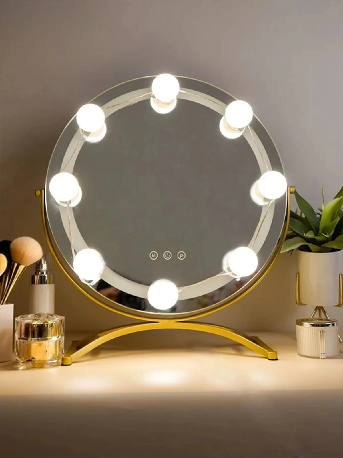 A round LED vanity mirror with multiple bright lights is displayed on a gold stand.