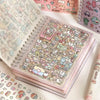 A close-up of a pastel pink sticker book filled with cute cartoon stickers for crafting and journaling.