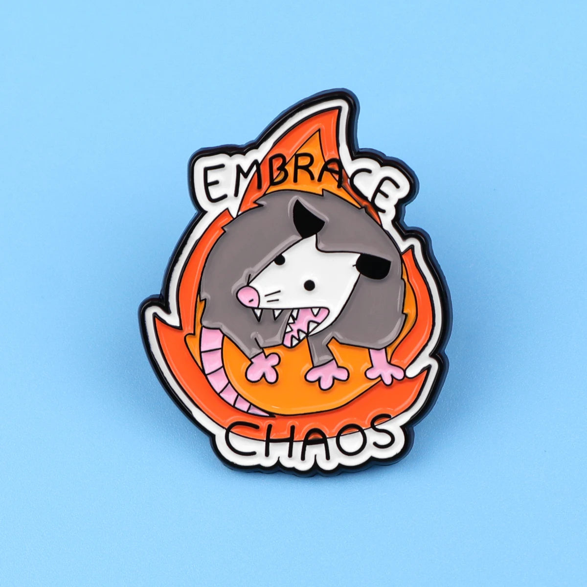 Broche émail avec la tête d'un loup féroce enveloppée de flammes, avec les mots 'Embrace Chaos' autour.