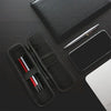 A black compact EVA hard shell pencil case with mesh pockets, a pen, and a smartphone are displayed on a dark surface.