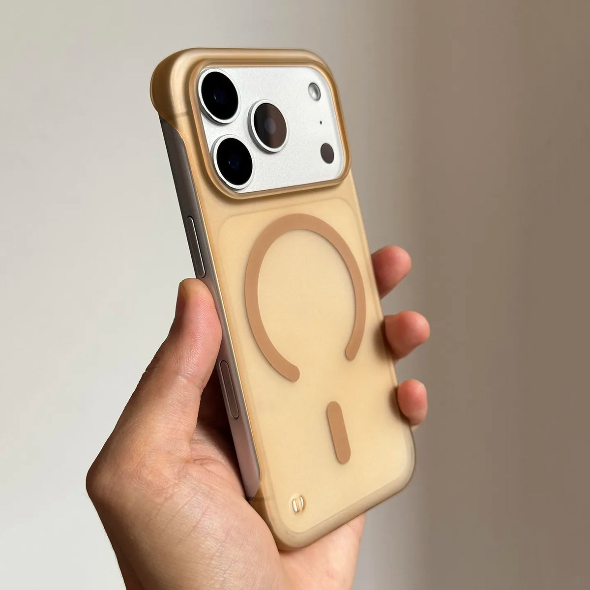 A hand holds a beige slim magnetic phone case for iPhone Magsafe with a circular cutout design.
