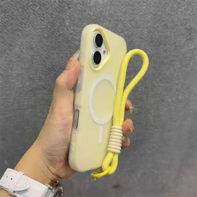 A hand holds a light yellow phone case with a lanyard, against a gray background.