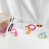 A white smartphone is shown with a pink magnetic grip and an orange foldable ring, next to its packaging box.