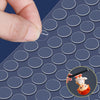 A hand places a removable double-sided adhesive dot onto a sheet of adhesive dots for crafts and decor.