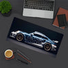 A detailed illustration of a blue and white JDM sports car on a dark mouse pad with a laptop and writing tools nearby.