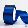 A roll of royal blue satin ribbon used for gift wrapping or DIY crafts.