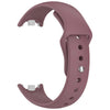 A close-up view of a mauve silicone replacement strap for a Mi Band watch.