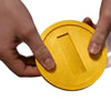 A hand is holding a yellow 3D printed shell card holder with an NFC tap-to-pay protection feature.