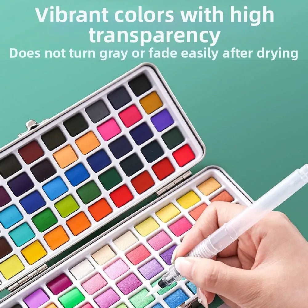 An open watercolor paint set showing various vibrant colors in a palette with a hand holding a brush.