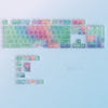 A colorful rainbow shine pc keycap set for a mechanical keyboard displayed on a light blue background.